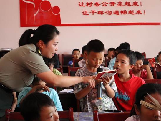 图七:红色宣讲团志愿者带领小朋友阅读分享连环画