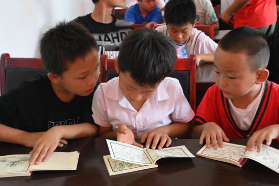 图八:小朋友们认真翻阅红色连环画